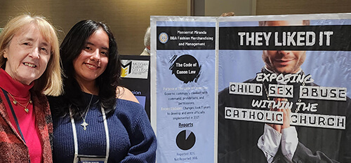  Two women pose next to a poster displaying the phrase they liked it